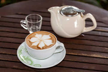 Coffee leaf placed on a wooden table.