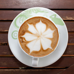 Coffee leaf placed on a wooden table.