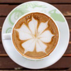Coffee leaf placed on a wooden table.
