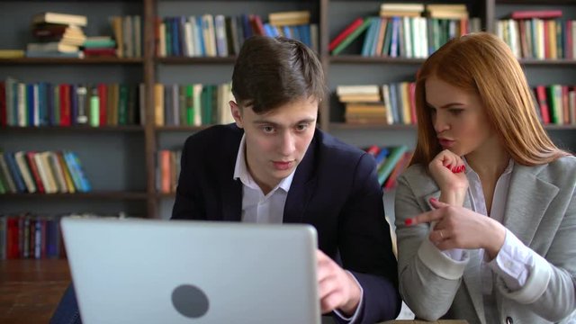 Caucasian man and woman shopping online with laptop. Portrait of millennial couple using computer and credit card. 4k Attractive young couple with technology shopping on the internet at home. 4 k