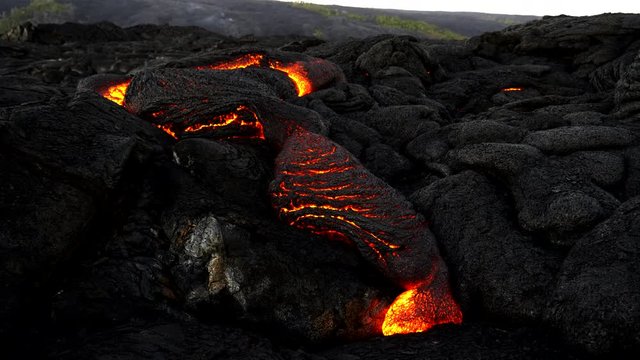 a wide shot of a slow lava flow from kilauea volcano on the big island of hawaii in the united states of america