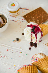 Ice-Cream Plombir In A Waffle Cup With A Topping Of Fresh Blueberries And Syrup, Grated Chocolate, Sprinkles, Overhead View.