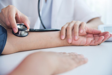 Female doctor measuring blood pressure.