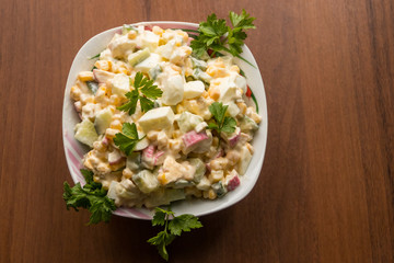 Salad with crab sticks, sweet corn, cucumber, eggs and mayonnaise