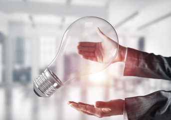 Good idea concept by means of lightbulb in hands.