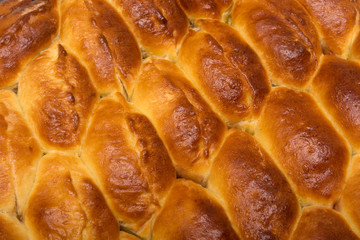 Homemade turnovers with filling are prepared  Latin American style. Concept of wheat spikes home brewing close-up as a background