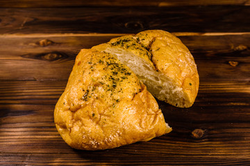Italian bun ciabatta with garlic on wooden table