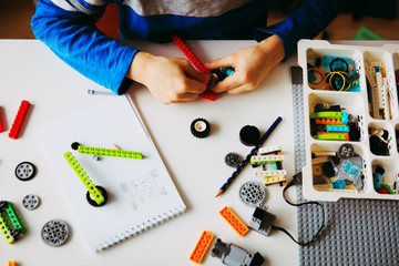 little boy building robot at robotic technology school lesson