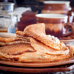 Homemade Russian pancakes on earthenware, selective focus, square