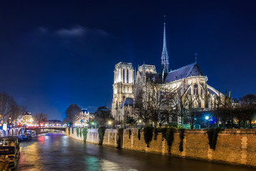 Fototapeta na wymiar View over Seine onto illuminatred back side of Notre Dame de Paris at night in Paris France