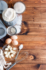 Baking background. Cooking ingredients for dough and wooden board on white rustic wood. Top view with copy space, recipe or culinary classes.