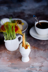 Appetizing breakfast of boiled eggs and strong aromatic tea on the background