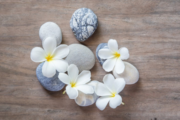 Fototapeta na wymiar frangipani flower and stone zen spa on wood