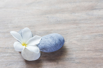 Fototapeta na wymiar frangipani flower and stone zen spa on wood