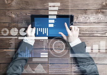 Business workplace with tablet device on wooden surface and media interface