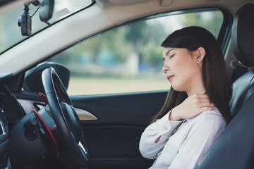 Fototapeta na wymiar Asian businesswoman having pain on her shoulder and neck while driving