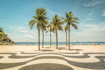 Fototapeta premium Palmy na plaży Copacabana i charakterystyczna mozaika w Rio de Janeiro w Brazylii