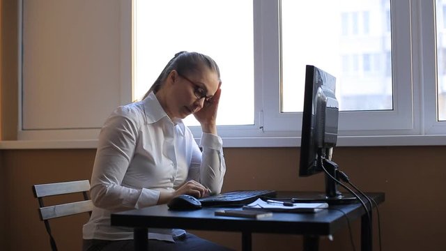 business woman works in office office computer. Compiles a financial report and scolds his employees by phone. Emotions, shouts, swears.