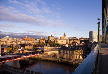 Fototapeta na wymiar Newcastle Upon Tyne Quayside and Grainger Town areas coloured golden at sunrise, with Tyne Bridge shadow cast across the buildings