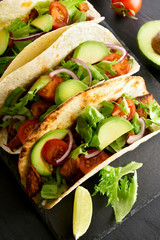 Tacos with meat and tomato, avocado, greens