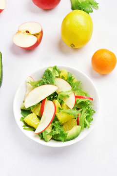 Salad with red apples, avocado, orange slices