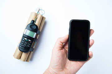 Homemade bomb on white background and phone in hand for control.