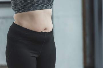 Close-up of curvy girl belly in gym