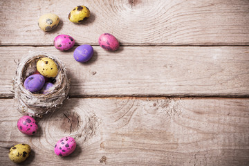 Easter eggs in nest on wooden background