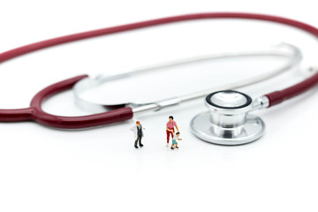 Miniature people : Doctor with mother and son on stethoscope background,heathcare concept.