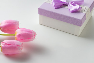 Three Pink Tulips and a Gift Box On The White Background. Artificial flowers. Copy space