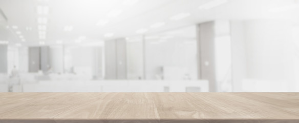 Empty wood table top and blurred bokeh office interior space banner background - can used for...