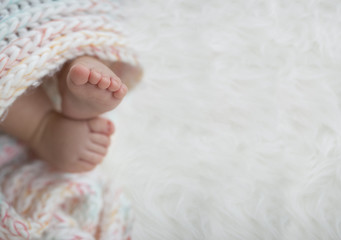 baby feet in blanket, copy space. selected focus