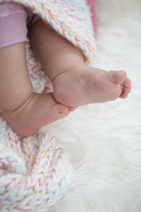 Baby feet on blanket showing emotions. Copy space. Selective focus