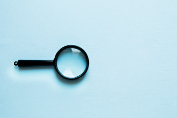 Black little Magnifier on a blue background