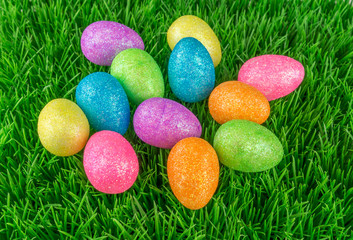 Colorful and glittering Easter eggs in the meadow