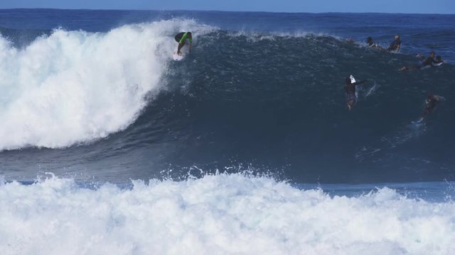 a 180p slow motion shot of a surfer getting a cover up at pipeline on the island of oahu in hawaii