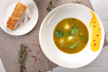 Sorrel soup in a white bowl, on a wooden table
