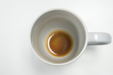 isolated white mug with coffee stain and residue at bottom on office desk