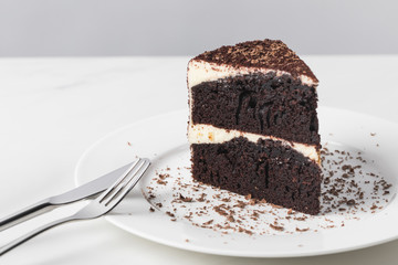 Closeup view of chocolate cake with glaze on white plate