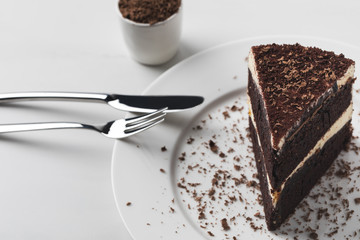 Cutlery on plate with cake and grated chocolate