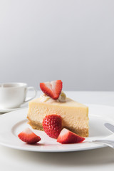 Closeup view of coffee cup and plate with strawberry cheesecake
