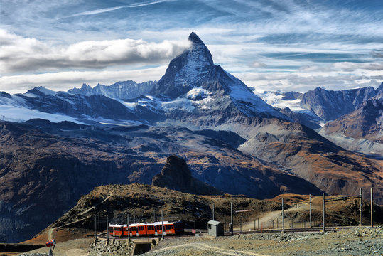 Zermatt Switzerland. Famous electric red tourist train coming down  in Zermatt
