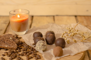 Fototapeta na wymiar handmade chocolate candys on wooden table with chocolate bread and coffee bean decorations 