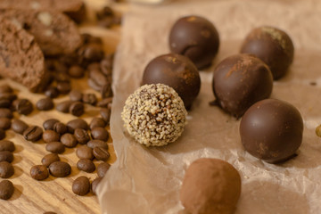 handmade chocolate candys on wooden table with chocolate bread and coffee bean decorations 
