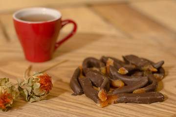 candied tropic fruits with chocolate on wooden table 