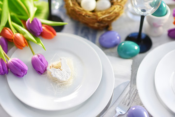 Fototapeta na wymiar Beautiful table setting with crockery and flowers for Easter celebration