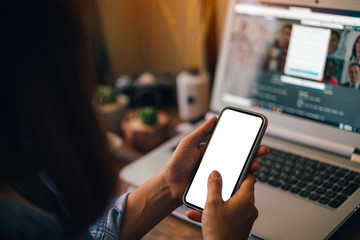 Woman holding a smartphone with white screen isolated on screen background.