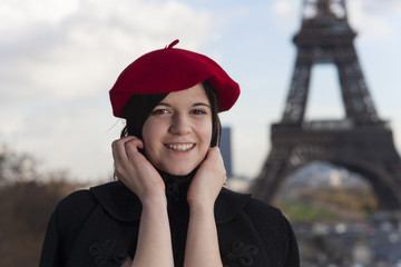 junge Frau mit einer Baskenmütze und dem Eiffelturm