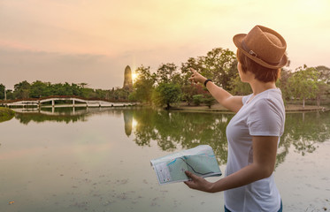 Tourist woman holding map and pointing to direction
