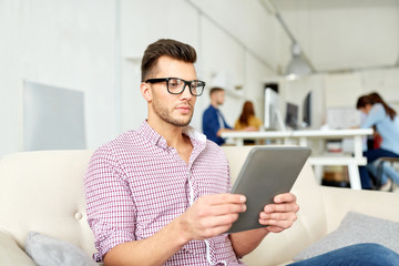 man in glasses with tablet pc working at office